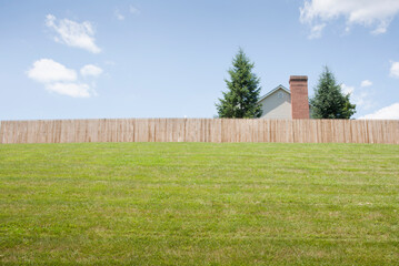 USA, New Jersey, Suburban house behind fence with lawn in foreground