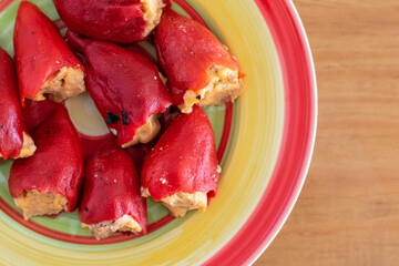 Peppers stuffed with meat in colorful plate and wooden table