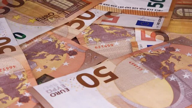 Loopable close up of numerous euro banknotes lying on top of each other  on a spinning plate.