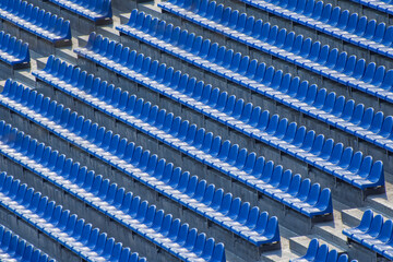 Empty blue stadium seats. Rows of chairs for seating in arena stadium.