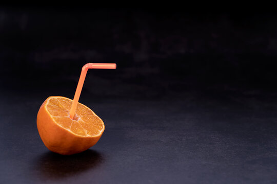 halbe Orange mit Strohalm