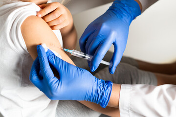 vaccination of children, a little girl at a doctor's appointment, an injection in the arm, the conce, close-up