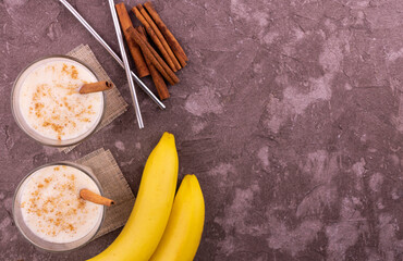 Banana cinnamon smoothie in a glass.
Flat lei.Copy space.