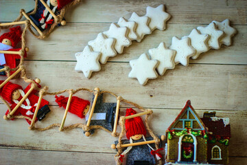 Festive Christmas background. Small elves in red hats and cookies in the shape of hexagonal stars.