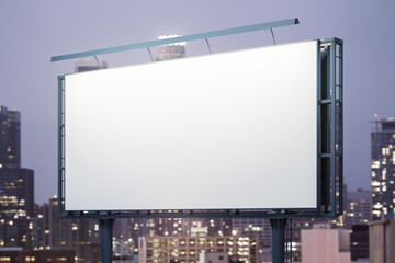 Blank white billboard on city buildings background at night, perspective view. Mockup, advertising concept