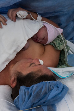 Mother lying in hospital with newborn baby girl (0-1 months)