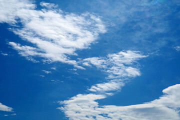 Amazing white clouds forming artistic shapes across vibrant blue sky