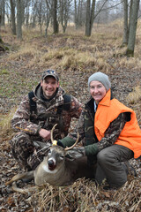 A pair of hunters with a young buck 