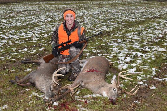 A hunter with a pair of trophy bucks,. 