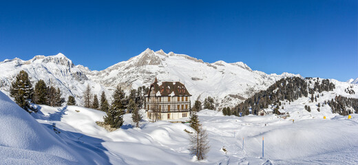 Fototapeta na wymiar Panorama of the winther landscape of Swiss Alps village Riederalp with the Pro Nature Center Villa Cassel 