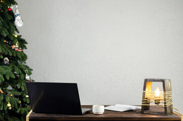 Laptop on the table. Open notebook, a cup of coffee. Desk lamp. Desktop. Workplace. Christmas new tree