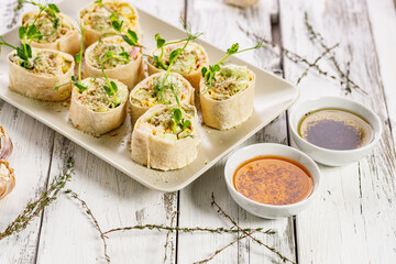 Tortilla deli wrap rolls with chicken ham and vegetable. White rustic background. Olive oil with tomatoes and basil. Wheat sandwich rolls with smoked chicken, cheese, cucumber, fresh salad. Copy space