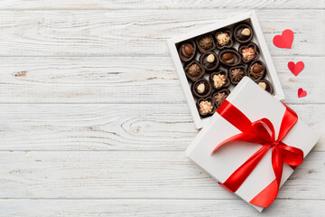 Delicious chocolate pralines in red box for Valentine's Day. Heart shaped box of chocolates top view with copy space