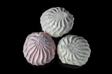 Top view aerial marshmallow dessert marshmallows. Three sweet pieces of marshmallow on a black background. Dessert meringue.