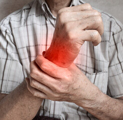 Pain in wrist joint of Asian elder man. Concept of hand pain, rheumatoid arthritis and arm problems.