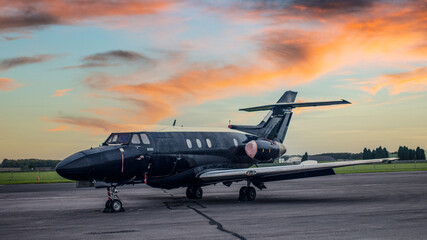 Fototapeta na wymiar Vintage training jet on the ground at sunset