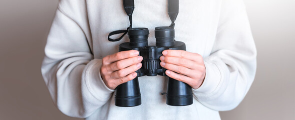 Close up of touristic binoculars hanging on female neck.
