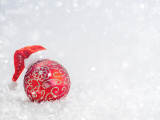 Red Glass Ball in Santa's Cap in the Snow.