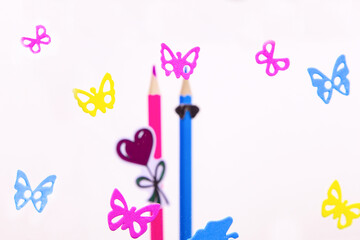 a couple in love. butterflies on a white background. colored wooden pencils. pink and blue pencils