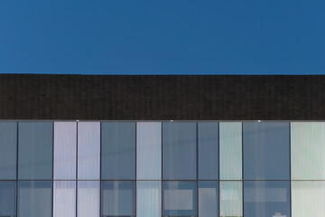 Daylight shot of a modern building with windows with a blue sky in the background