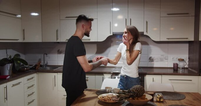 The guy playfully puts the ring on the girl's finger