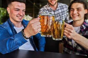 Close up photo of two glasses of beer in man hands.
