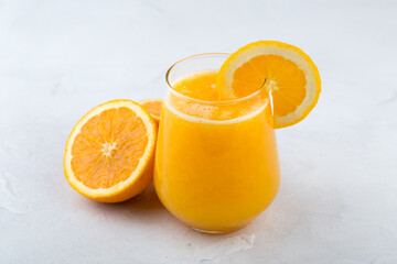 Orange juice in glass on gray background