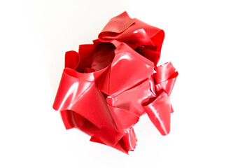 A lump of crumpled used red duct tape on white background