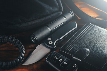 EDC set. Items for Everyday Carry use. Automatic Knife, car keys, paracord bracelet, wallet and tactical bag. Accessories in urban military style for man.