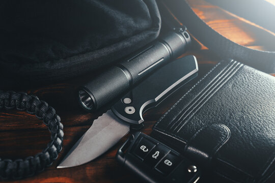 EDC set. Items for Everyday Carry use. Automatic Knife, car keys, paracord bracelet, wallet and tactical bag. Accessories in urban military style for man.