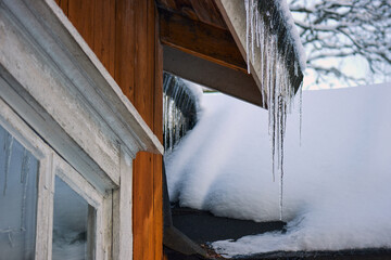 Old Finnish house at the end of winter with icicles.