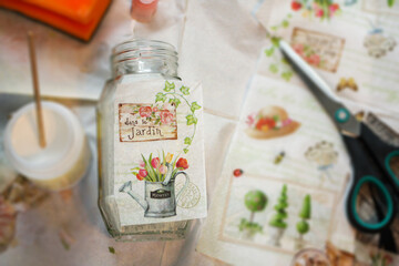 Decoupage process with a glass jar, vase. Glue, brush, scissors and paper napkins. Top view. Creativity, hobby, DIY background - obrazy, fototapety, plakaty
