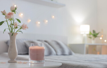 Obraz na płótnie Canvas pink roses in vase on table in bedroom