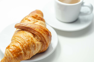 Croissant with chocolate on a plate with coffee in a cup