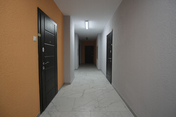 Warm orange and white walls at corridor inside apartment building