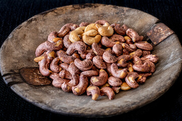 Many cashews in the old rustic wooden bowl