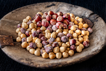 Many hazelnuts in the old rustic wooden bowl