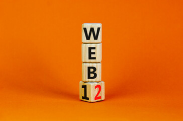 WEB 1 or 2 symbol. Turned a wooden cube and changed words WEB 1 to WEB 2. Beautiful orange table, orange background, copy space. Business, technology and WEB 1 or 2 concept.