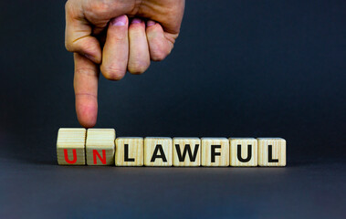 Lawful or unlawful symbol. Businessman turns wooden cubes and changes the word unlawful to lawful....