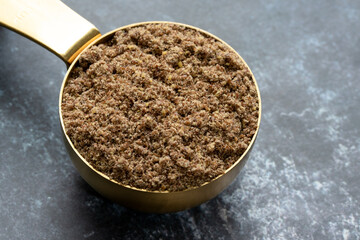 Flaxseed Meal in a Gold Measuring Cup