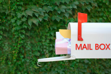 Mail box with gift and letters outdoors