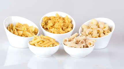Pasta in a white bowl, isolated on a white background with reflection.