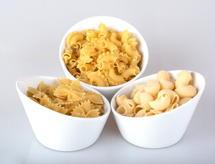 Pasta in a white bowl, isolated on a white background with reflection.