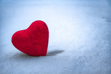 Fototapeta premium lonely heart of red in the blue snow