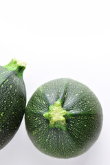 Vertical shot and zenith view, round zucchini on light background. Copy space.