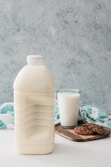 Obraz na płótnie Canvas Gallon bottle, glass of milk and cookies on table