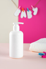 Obraz na płótnie Canvas Natural Hypoallergenic Foam for bathing children. White Plastic pump bottle. children's cosmetics. Bottles on a minimalistic fuchsia - pink background and a soft towel. Mock up.