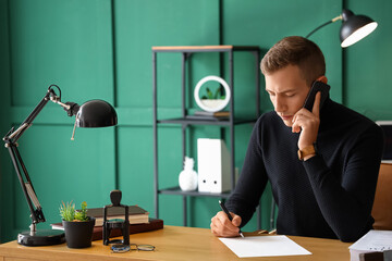 Male notary public speaking by phone in office