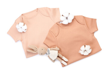 Baby bodysuits, toy and cotton flowers on white background