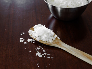 Soy wax in a wooden spoon. Soy wax for candles. Vegan